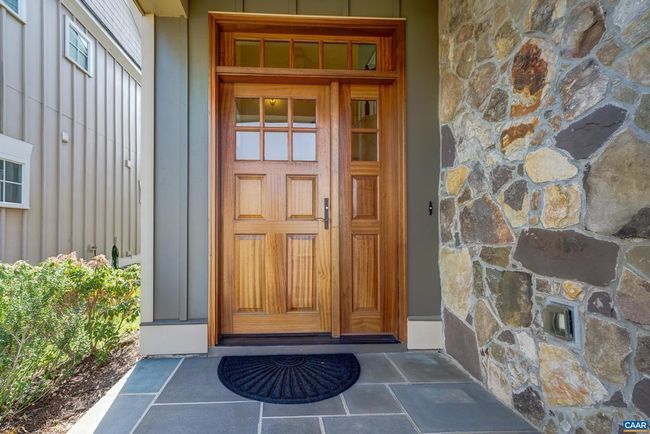 Bluestone covered front porch and solid wood front door with side light and transom welcome you home. | Image 4