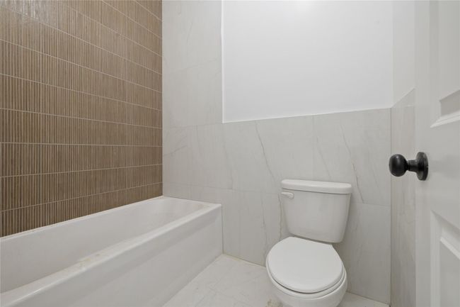 Bathroom with tile walls, toilet, and marble finish flooring | Image 27