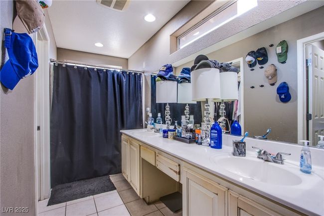Full bathroom with tile patterned floors, double vanity, and a shower with curtain | Image 18