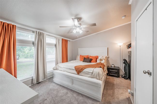 Bedroom with carpet floors, ceiling fan, and crown molding | Image 17