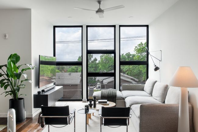 Living room with plenty of natural light, wood finished floors, floor to ceiling windows, and a ceiling fan | Image 6