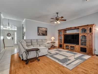 Living room featuring light hardwood / wood-style floors, ornamental molding, and ceiling fan | Image 3