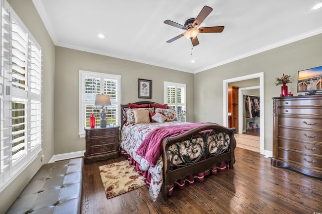 Bedroom with wood finished floors, baseboards, ornamental molding, a ceiling fan, and recessed lighting | Image 22