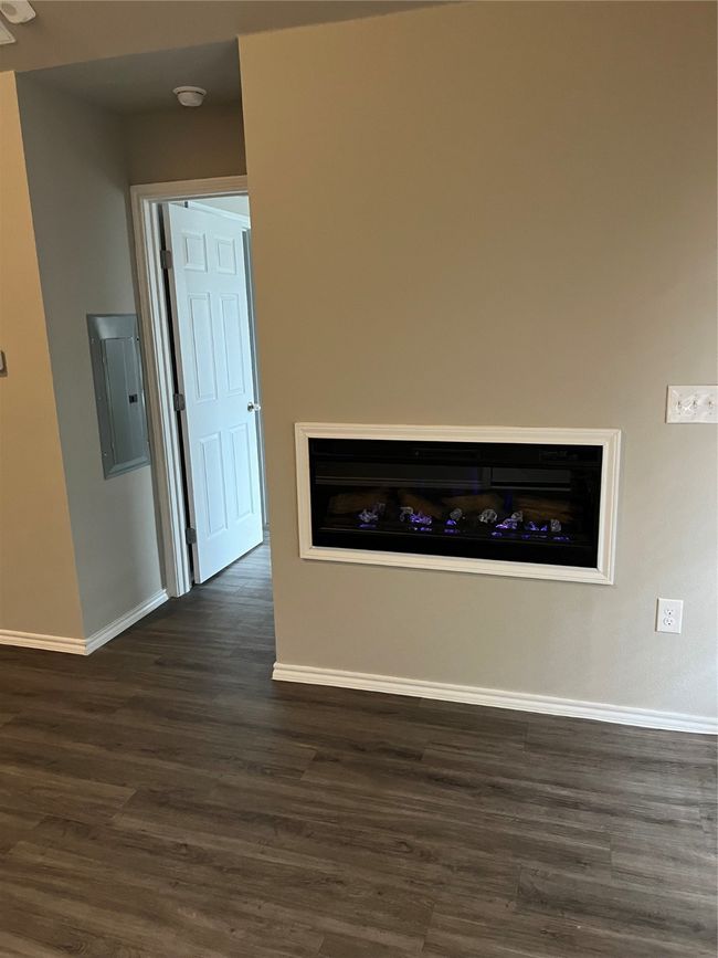 Detailed view of electric panel, baseboards, wood finished floors, and a smoke detector | Image 4
