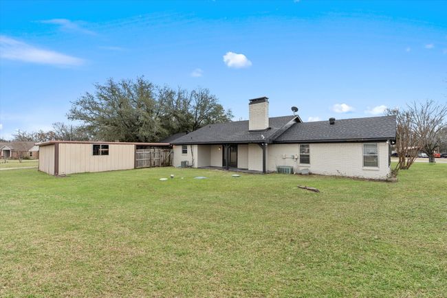 Rear view of property featuring cooling unit and a lawn | Image 25