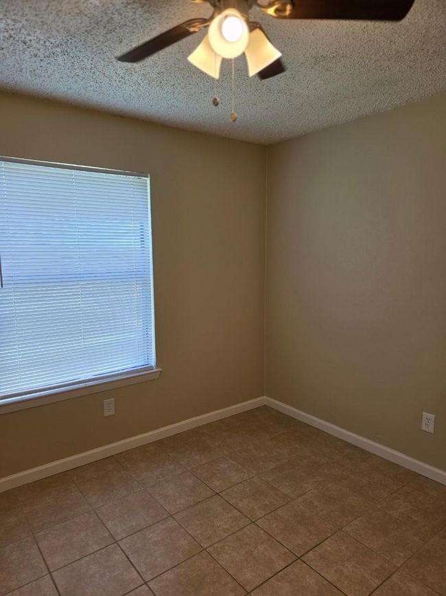 Tiled spare room with ceiling fan and a textured ceiling | Image 11
