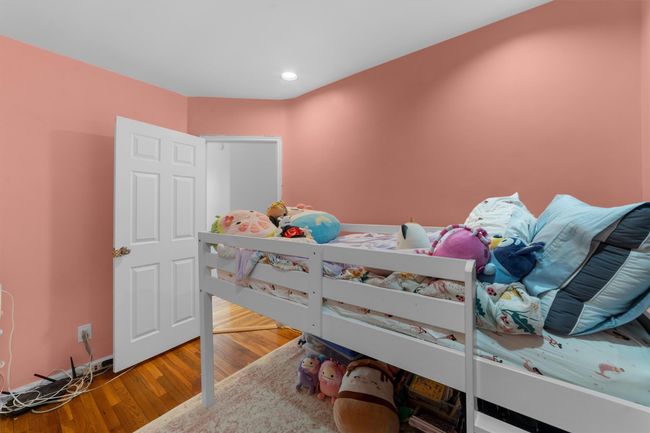 Bedroom with wood finished floors and recessed lighting | Image 21