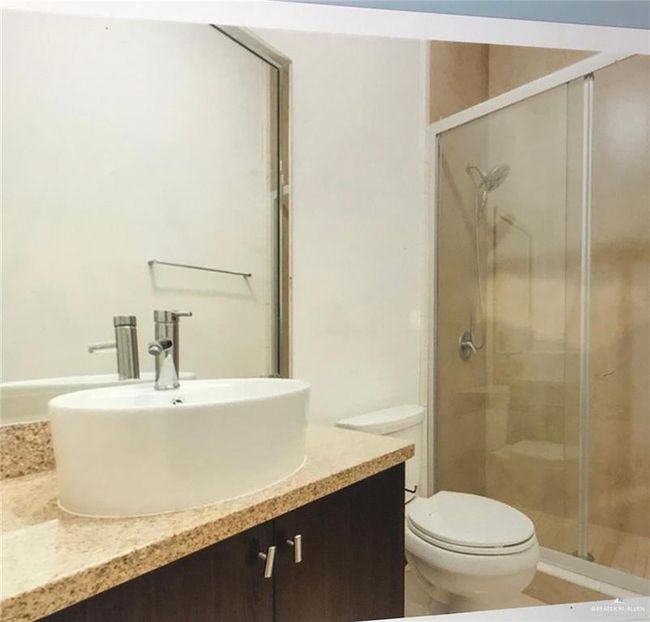 Full bath featuring a shower stall, vanity, and toilet | Image 11