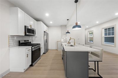 Kitchen with pendant lighting, white cabinetry, appliances with stainless steel finishes, and sink | Image 3