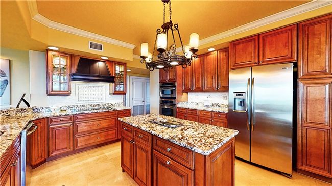 Gourmet Kitchen with tons of cabinets and pantry storage with ocean views from kitchen in to living room and breakfast rooms. | Image 7