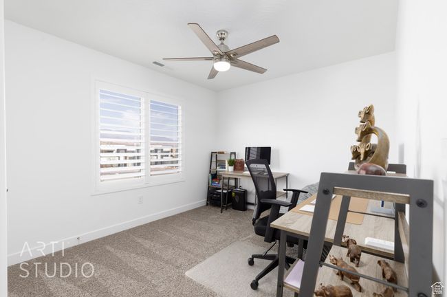 Carpeted home office with baseboards, visible vents, and ceiling fan | Image 25