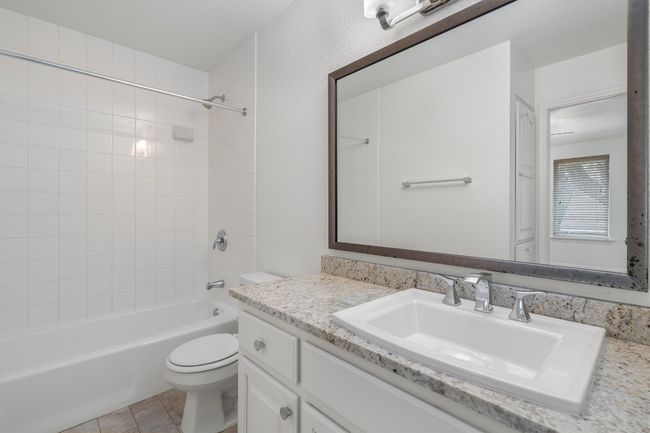 Full bath with vanity, tile patterned floors, toilet, and bathing tub / shower combination | Image 19