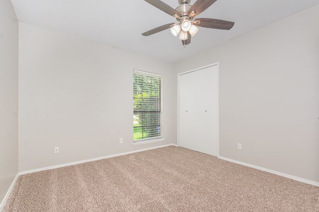Carpeted empty room with ceiling fan and baseboards | Image 17