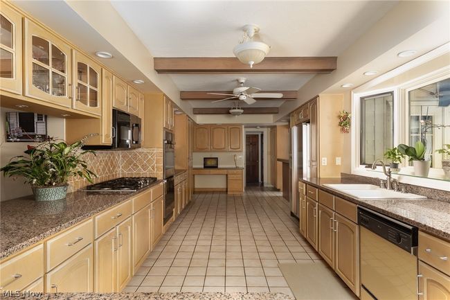 Kitchen with appliances with stainless steel finishes, beam ceiling, sink, ceiling fan, and light tile floors | Image 23