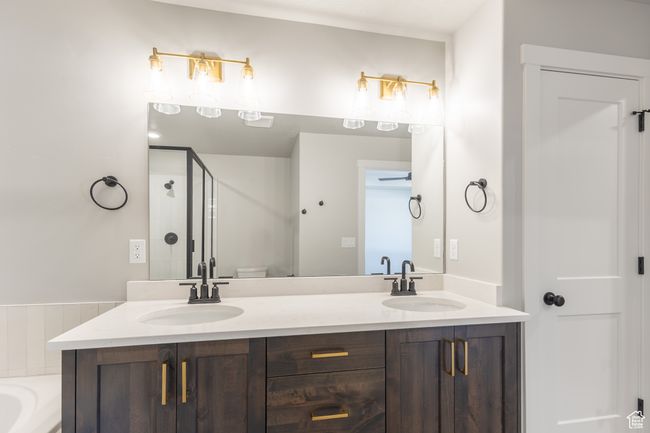 Bathroom featuring double vanity, a stall shower, and a tub | Image 20