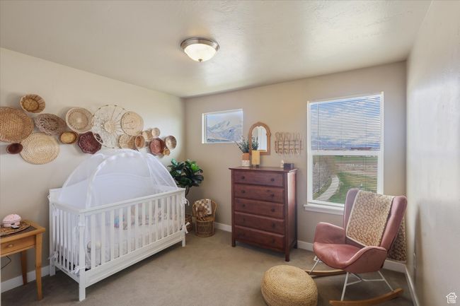 Carpeted bedroom featuring a crib and baseboards | Image 10