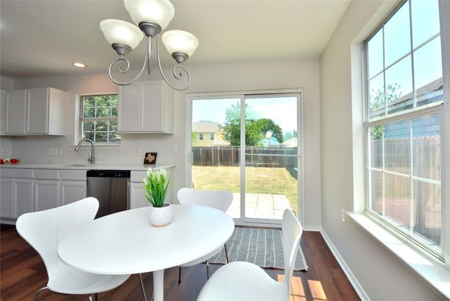 Dining area featuring dark wood-style flooring, baseboards, a chandelier, and recessed lighting | Image 6