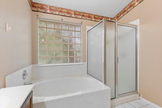 Full bathroom with a bath, a stall shower, vanity, and tile patterned flooring | Image 22
