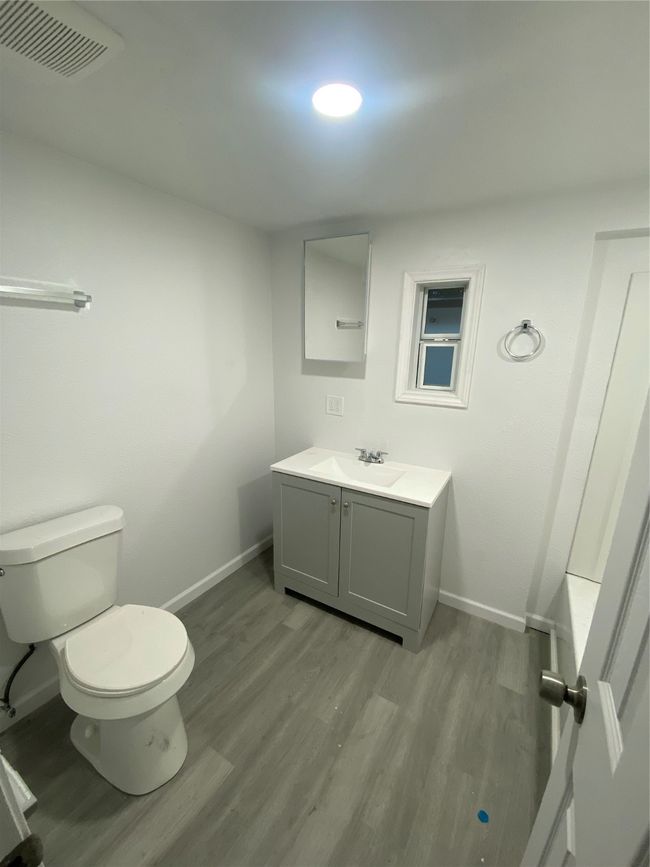 Bathroom with wood finished floors, baseboards, toilet, and vanity | Image 10