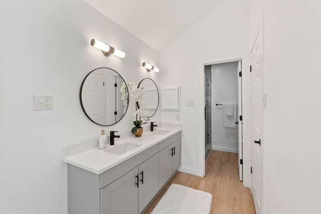 Lofted ceiling, wood finished floors, a sink, and double vanity | Image 25