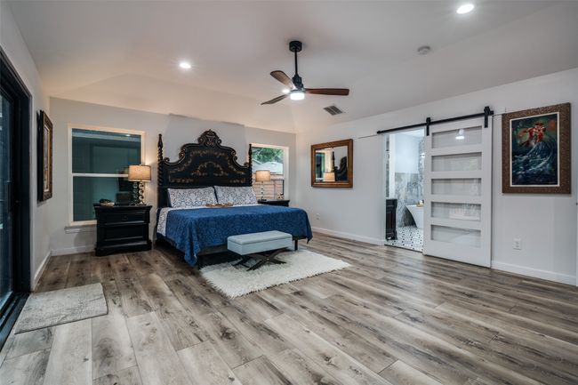 Bedroom featuring a barn door, wood finished floors, recessed lighting, and ceiling fan | Image 17