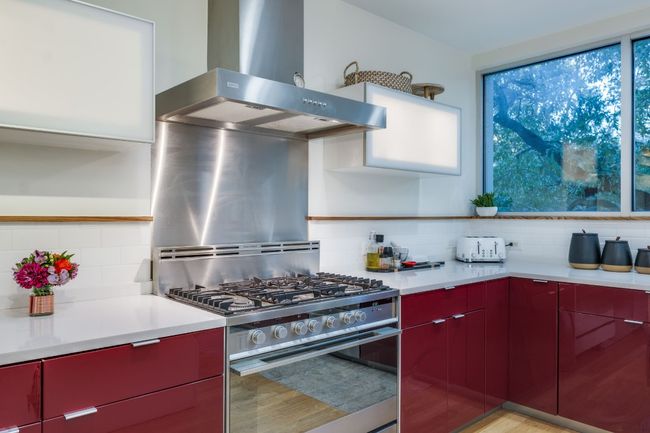 Kitchen featuring tasteful backsplash, exhaust hood, stainless steel gas range, and light hardwood / wood-style floors | Image 15