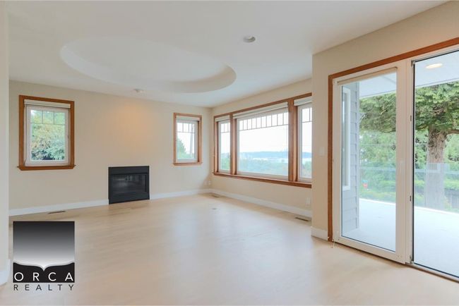 Unfurnished living room featuring light wood finished floors, a glass covered fireplace, and recessed lighting | Image 4