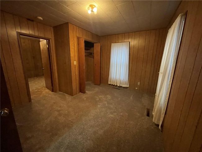 Unfurnished bedroom featuring a closet and wood walls | Image 12