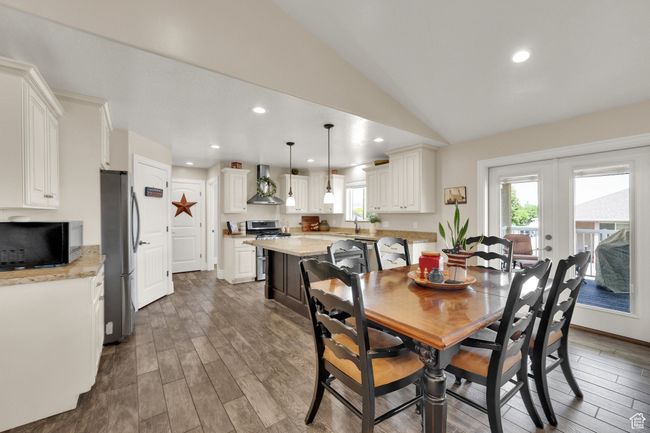 Dining room with wood finished floors, lofted ceiling, recessed lighting, and french doors | Image 6