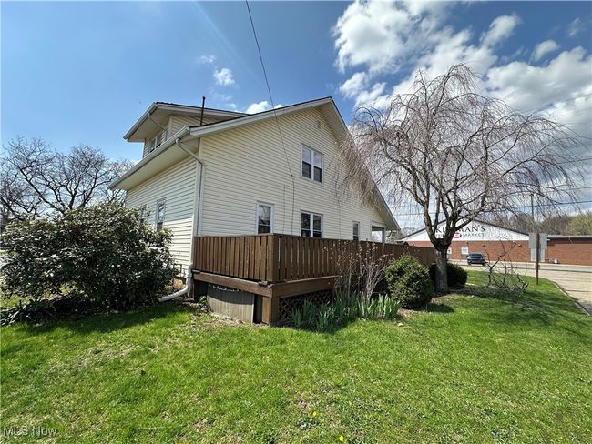 View of property exterior featuring a wooden deck and a yard | Image 22