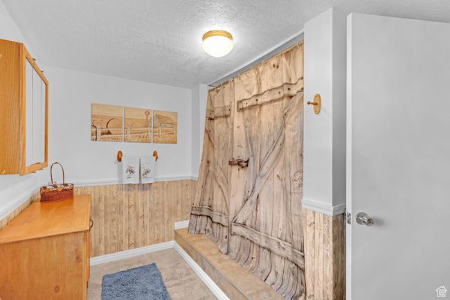 Bathroom with a textured ceiling and wooden walls | Image 27