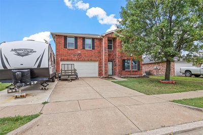 View of front of home with a front yard, a garage, and central AC unit | Image 2