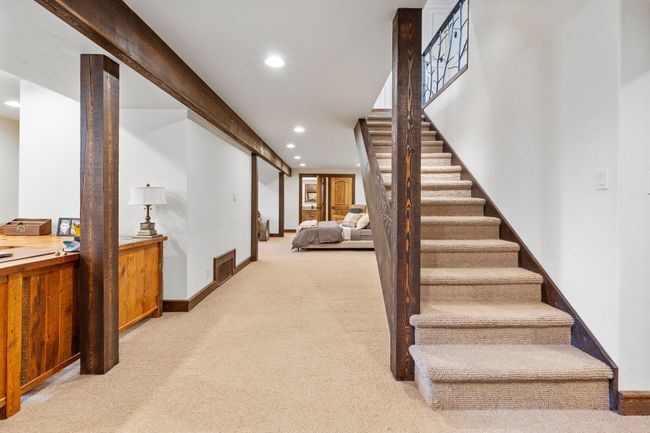 Staircase from Main Floor to Lower Level, featuring: Office space, family room, Large Walk in Closet, Laundry Room, bathroom. | Image 51