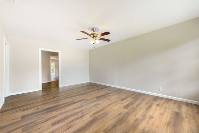 Unfurnished room with a ceiling fan and wood finished floors | Image 15
