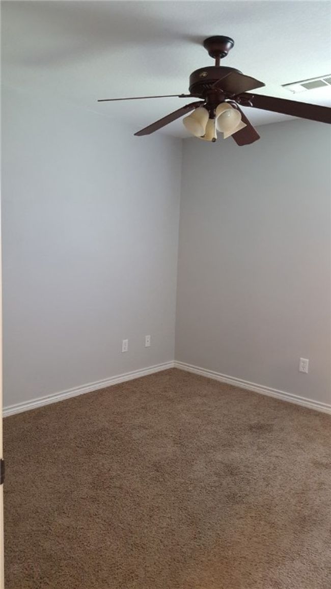 Carpeted empty room featuring ceiling fan and baseboards | Image 13