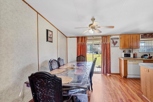 Dining room with light wood finished floors, ceiling fan, and ornamental molding | Image 7