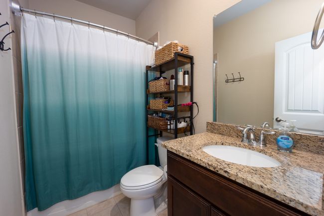 Downstairs Full bath featuring vanity, tile patterned flooring, and shower / bath combination with curtain | Image 16