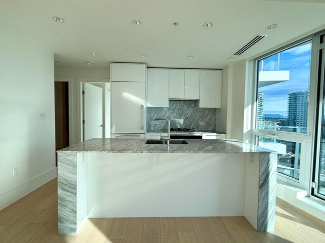Kitchen with a sink, white cabinetry, modern cabinets, fridge, and visible vents | Image 8
