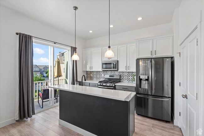 Kitchen featuring stainless steel appliances, backsplash, pendant lights, and quartz countertop | Image 4