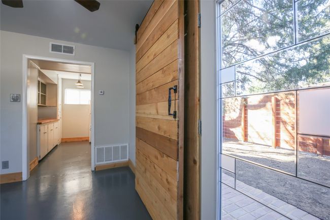 Doorway with ceiling fan and finished concrete floors | Image 7