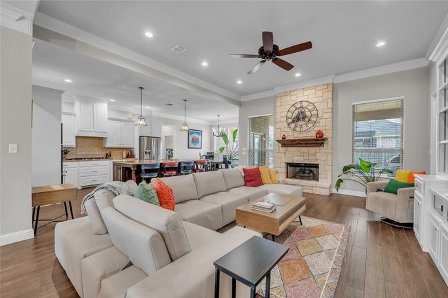 Living room with ceiling fan, dark wood-type flooring, recessed lighting, ornamental molding, and baseboards | Image 8