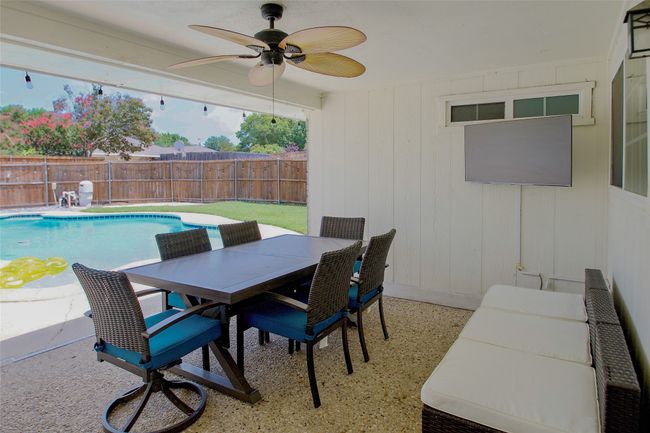 View of swimming pool with a fenced backyard, ceiling fan, outdoor dining space, and a patio area | Image 30