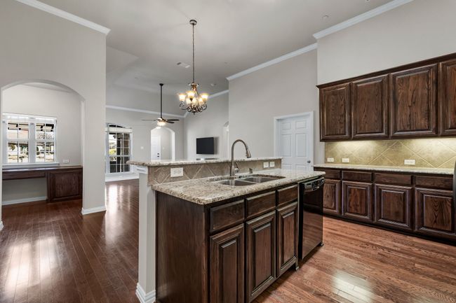 Eat-in kitchen features sleek granite countertops and center island | Image 19