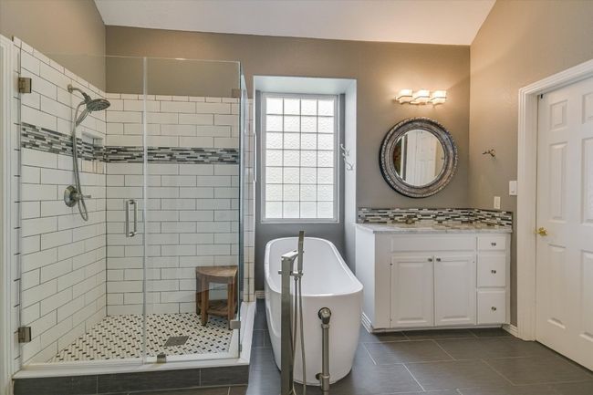 Full bathroom featuring a shower stall, tile patterned flooring, a soaking tub, and plenty of natural light | Image 17