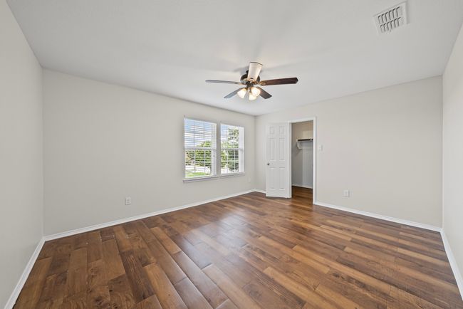 Unfurnished bedroom featuring dark wood-style flooring, ceiling fan, and a spacious closet | Image 29