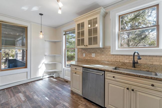 Kitchen with dishwasher, a sink, decorative backsplash, glass insert cabinets, and dark wood-type flooring | Image 18