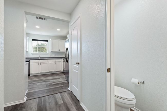 Bathroom featuring a toilet, Grey wood-style vinyl floors, vanity, recessed lighting, and a textured wall | Image 15