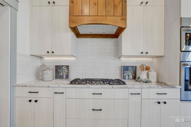 Kitchen featuring appliances with stainless steel finishes, decorative backsplash, and light stone countertops | Image 14