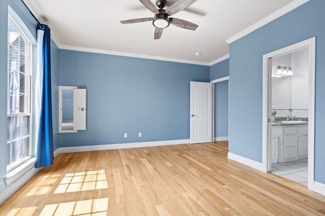 Bright guest room offers beautiful wood floors, ample window light, and an attached bathroom | Image 28
