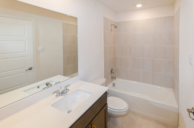 Bathroom featuring toilet, vanity, tub / shower combination, recessed lighting, and tile patterned floors | Image 26